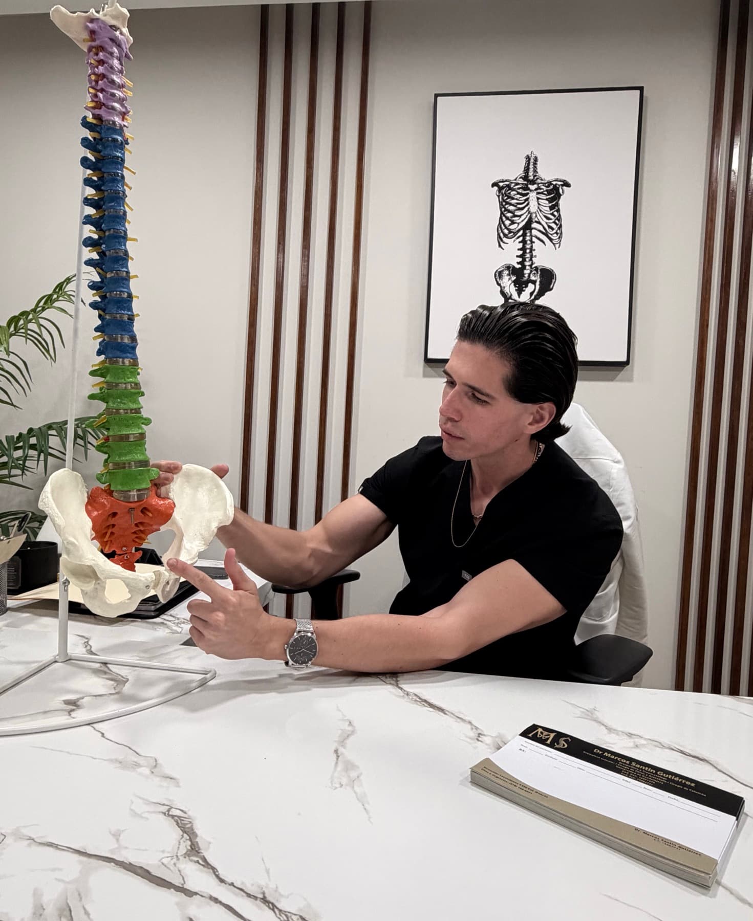 El Dr. Marcos Santin explicando sobre un modelo anatómico de columna y pelvis
